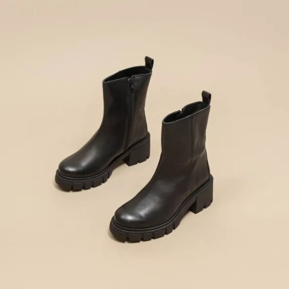 Heeled boots with notched soles in black leather