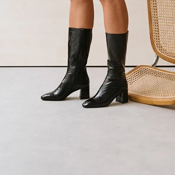 Heeled boots with pointed toe in black glazed leather