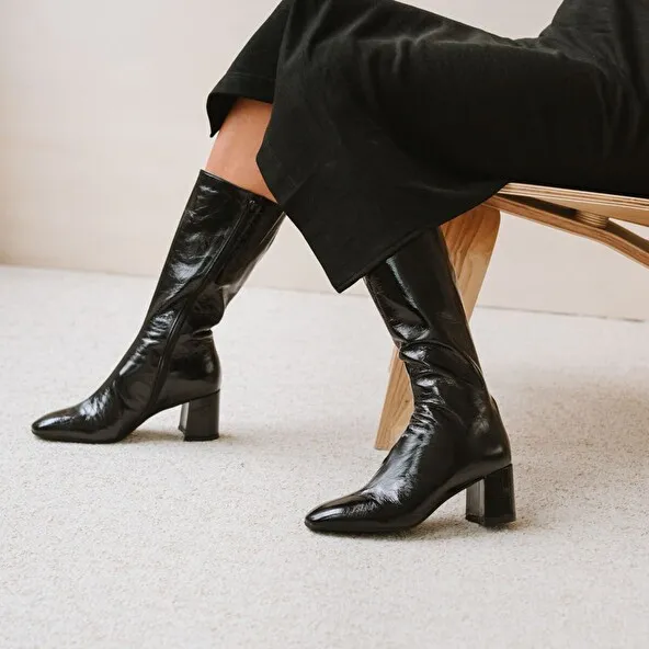 Heeled boots with pointed toe in black glazed leather